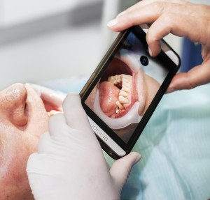 Dentist's,Hands,With,A,Smartphone,Taking,A,Photo,Of,Patient's